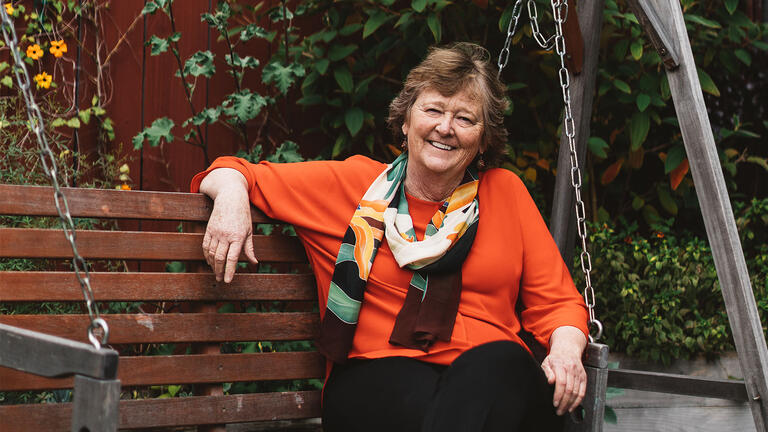 Martha Ryan sits on a garden swing.