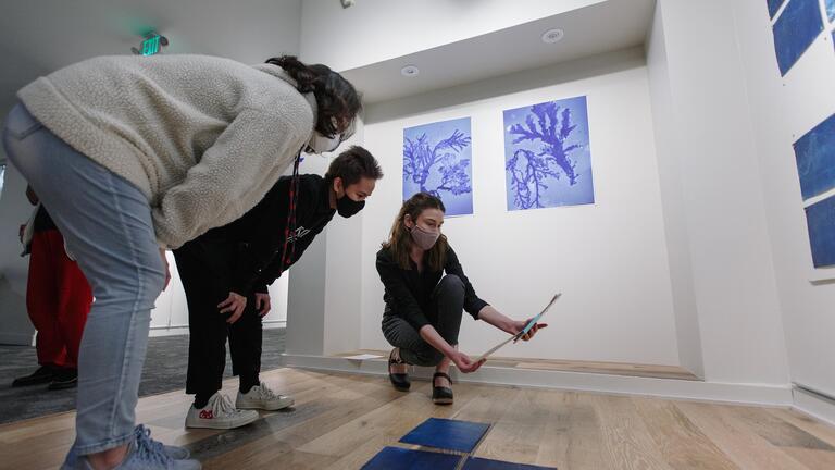 Students and professors examine fine art prints during art installation at Thacher Gallery