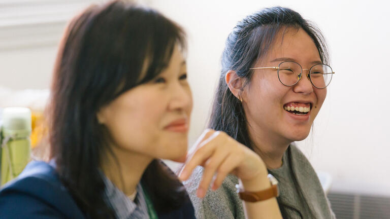 Two students smiling in class.
