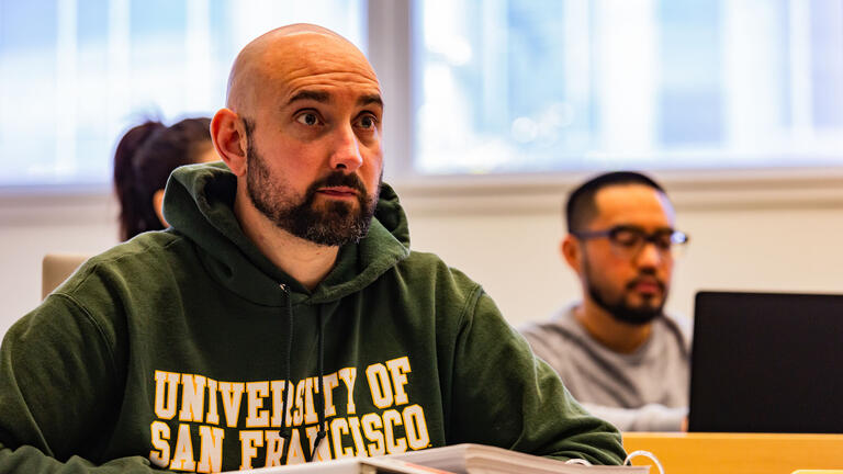 Student in a USF sweatshirt pays attention in class.