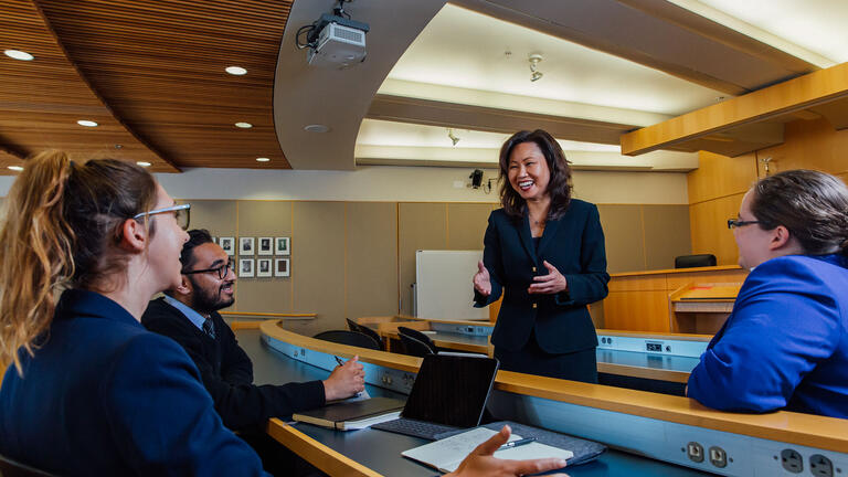 Professor and students talk in the moot court.