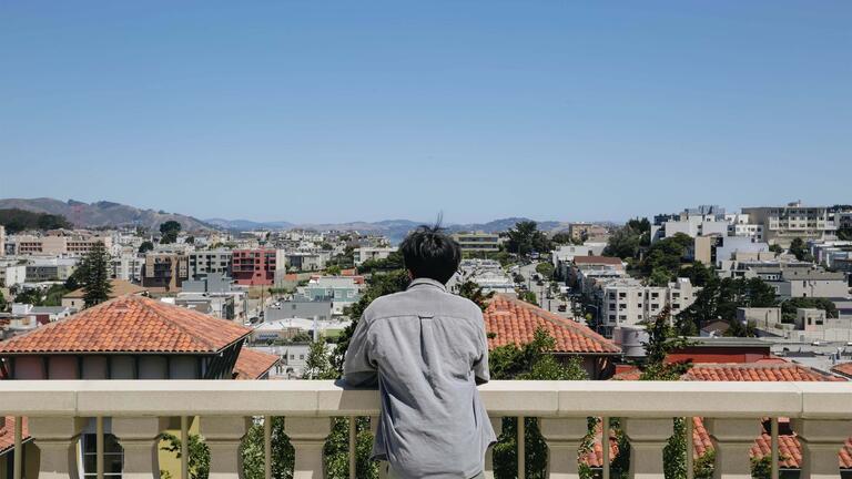 Student looks at the city from a view on Lone Mountain.