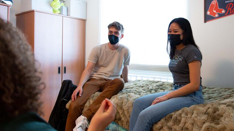 Students talk in a dorm room.