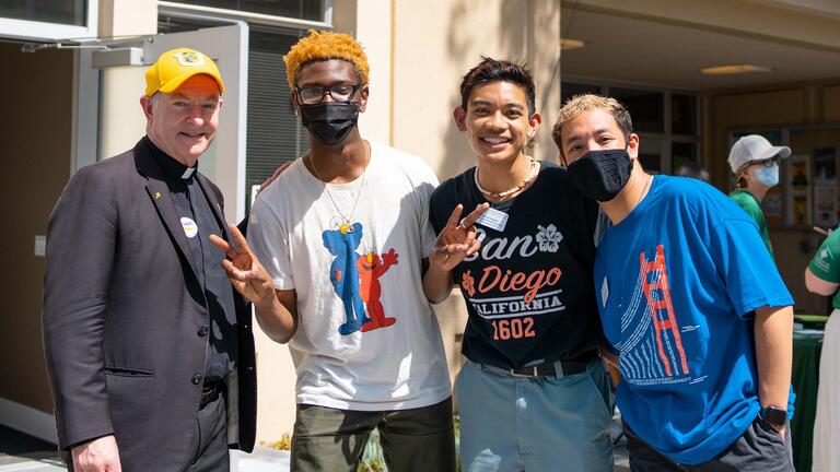 Students pose with USF President Fr. Fitzgerald on campus.