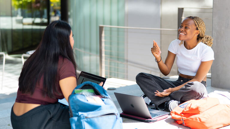 Two students talk over lunch in Lo Schiavo Science.
