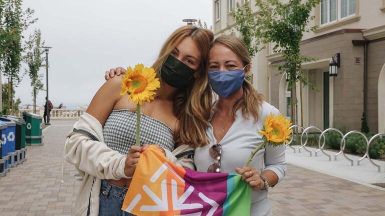 Student hugs her mother in front of the dorms.