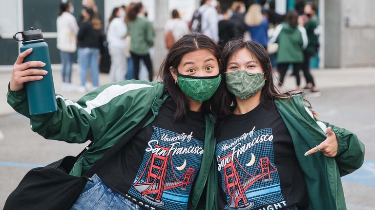 Two students point to their shirts that advertises Koret Night.