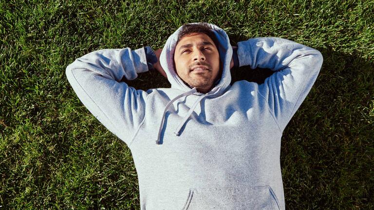 Paresh Ravikumar ’15 laying on the grass