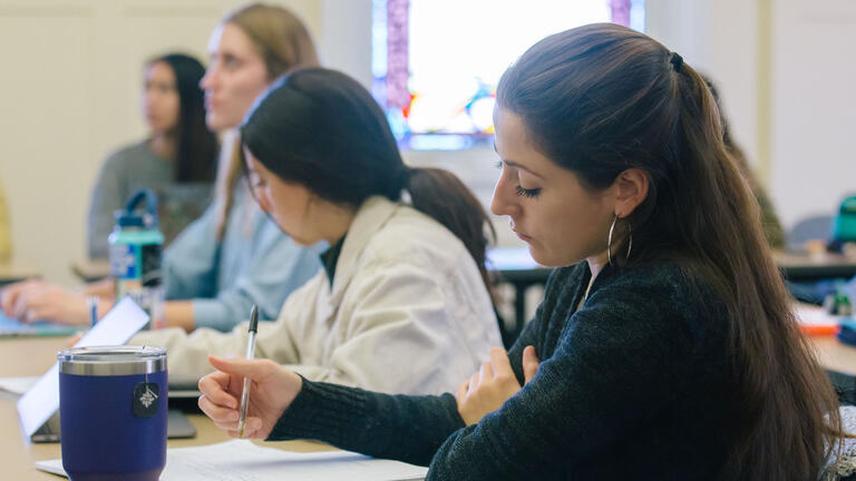 Students writing in classroom.