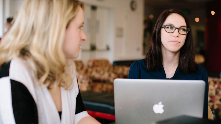 Two students sit at desk