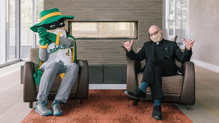 Fr. Fitzgerald sits with USF Dons mascot