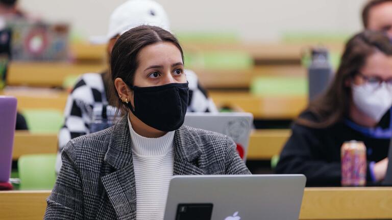 Student listens attentively in lecture hall with other students