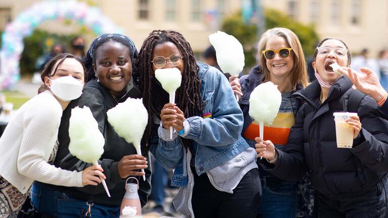 Group of students pose for a picture holding cotton candy.