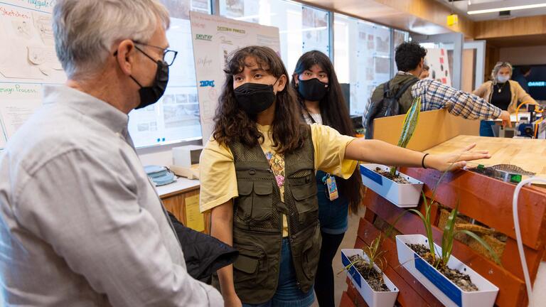 A faculty member speaks with a student about an engineering project.