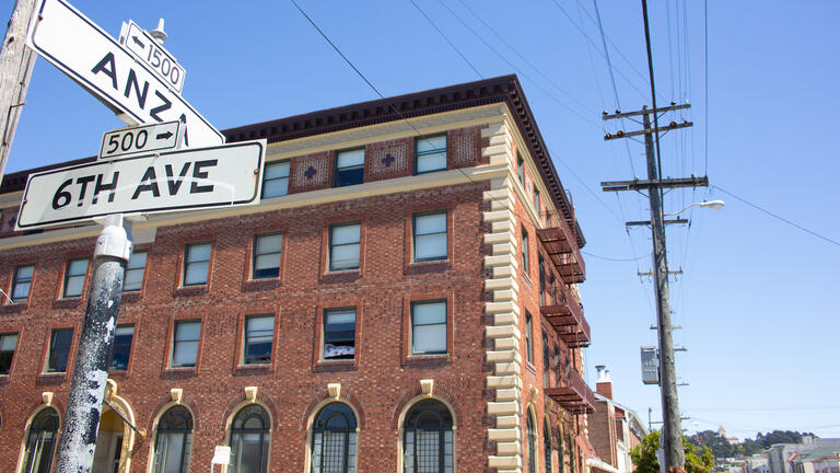 View of Pedro Arrupe residence hall with street signs in foreground