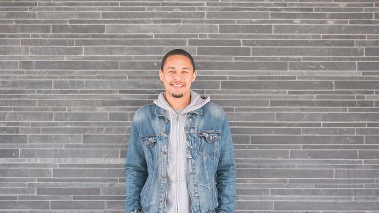 Student posing in front of wall.