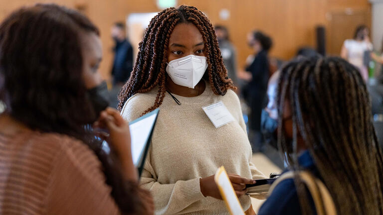 Students talk to staff at event.