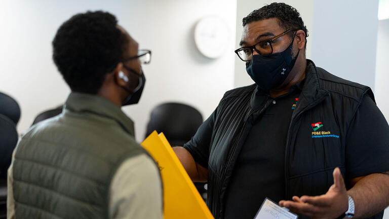 Staff member speaks with a student at event.