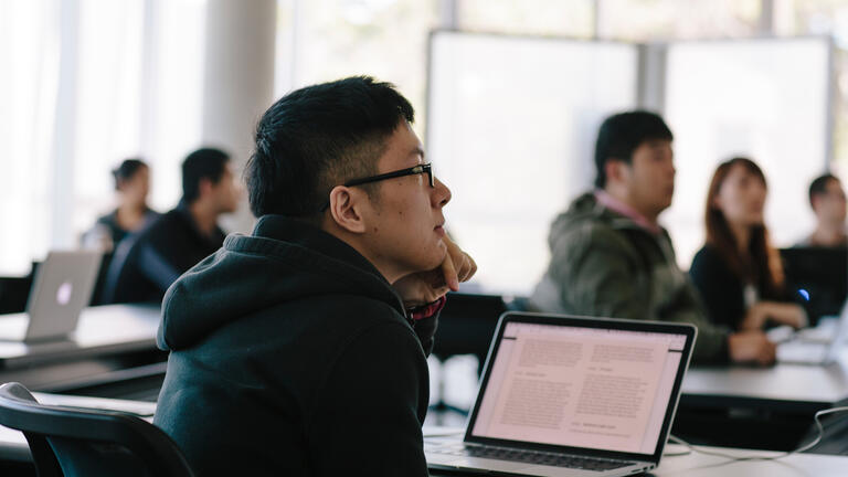 student in class with laptop