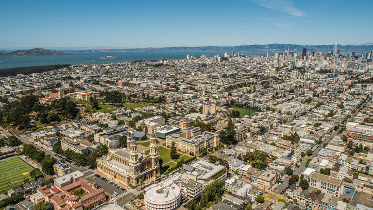 USF campus with San Francisco skyline in background.