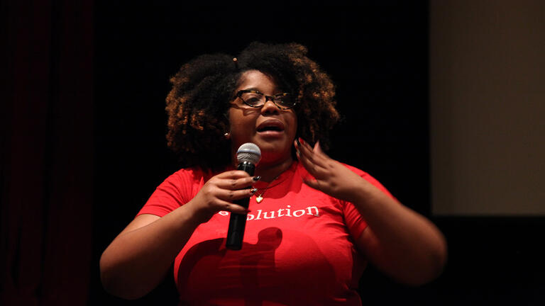 woman holding microphone speaking at event