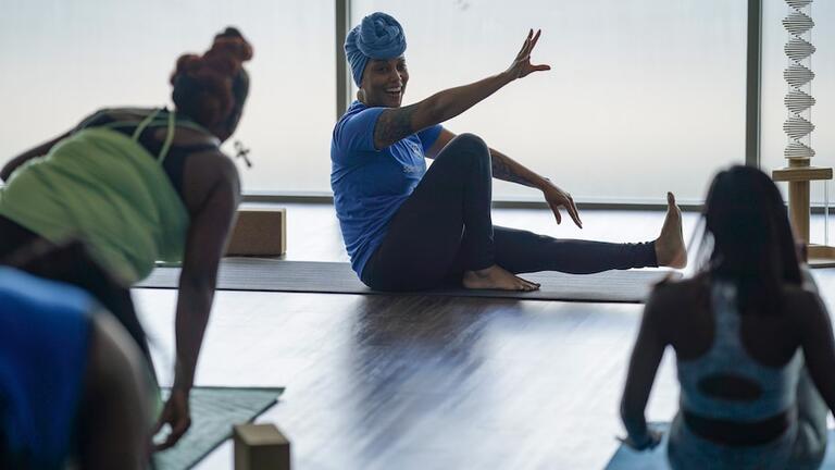 Teacher leads a yoga class in a high rise building.