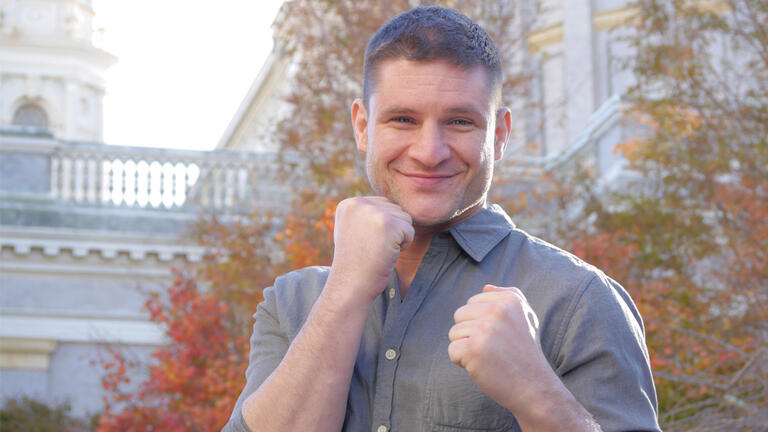 Nick Stagnaro posing with two fists up in front of St. Ignatius