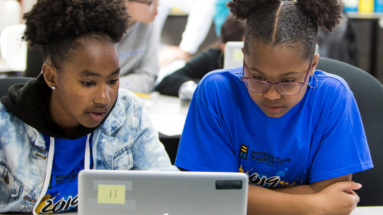 Two students in front of a computer