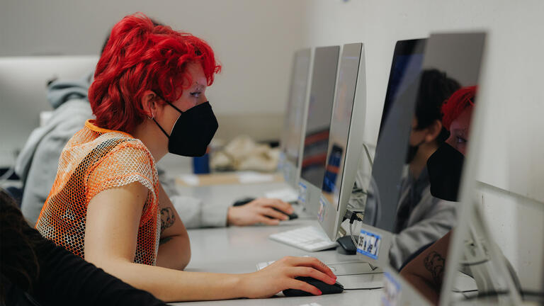 Student works at a computer in a computer lab.