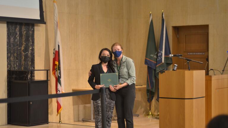 Two people holding an award