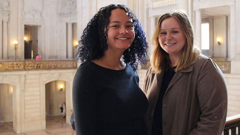 Two students pose in SF City Hall