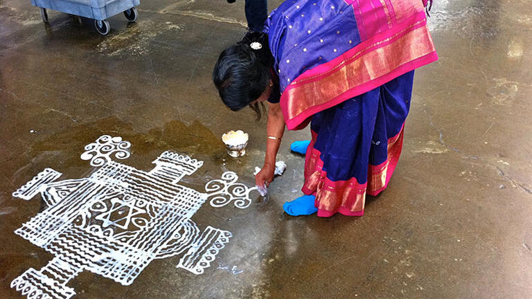 Woman painting the ground — Image credit: Pichammal Nagarajan kōlam, TedX GoldenGate, Crane Pavillion, Richmond, CA 2011. Photo: Lee Swenson