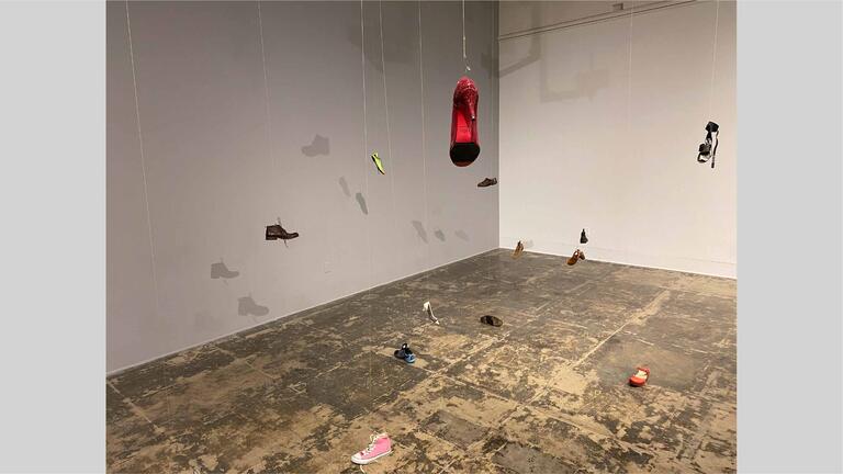 Shoes dangling from the ceiling, hung up by wire