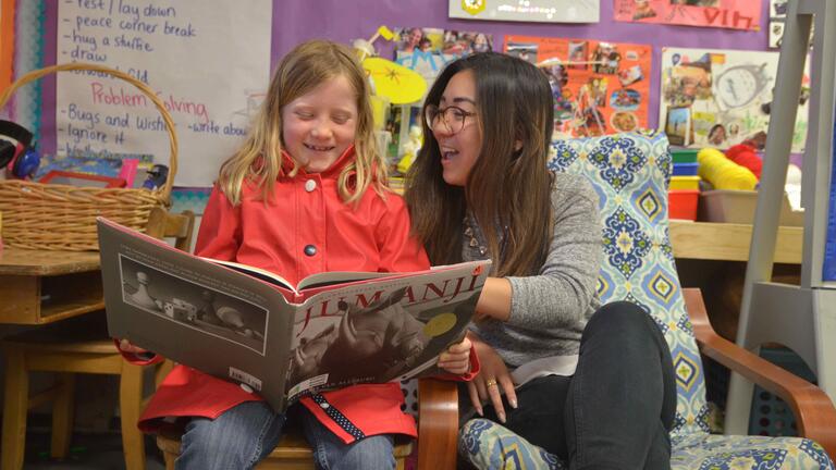 Student reading with a child