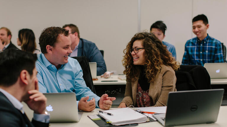 Two students chatting and working together at USF's downtown campus