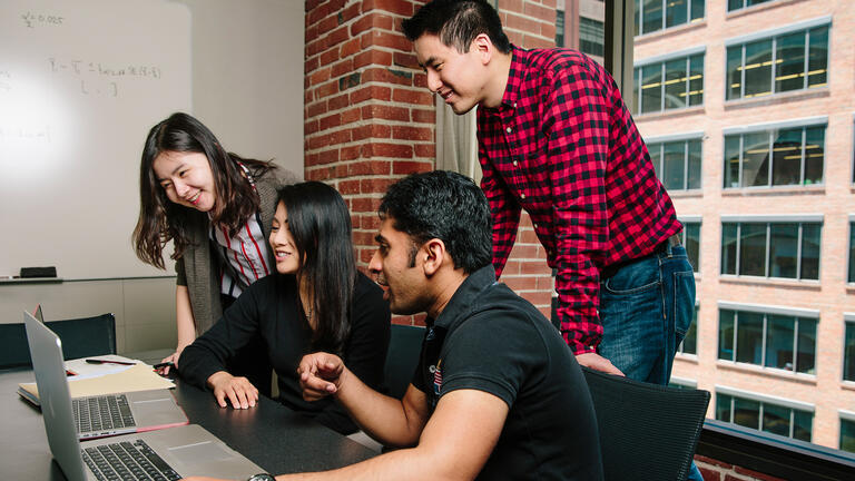 students in class overlooking laptops