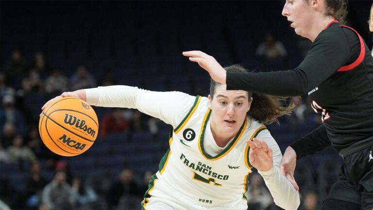 USF women&#039;s basketball player charging past defense. 