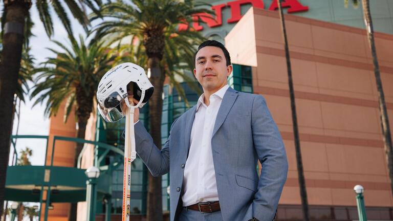 USF Student holding a hockey helmet in front of the Honda Center 