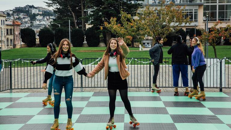 Friends roller skate together on campus