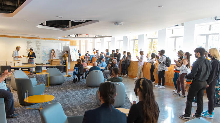 Large group of students and professors gathered in innovation lab