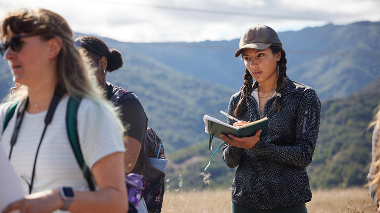 student taking notes while standing outside at Quicksilver County Park