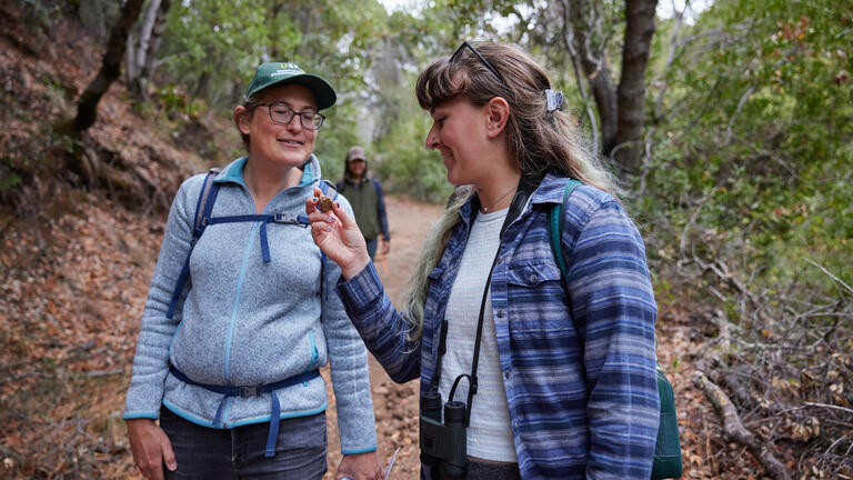 student and teacher walking in a park