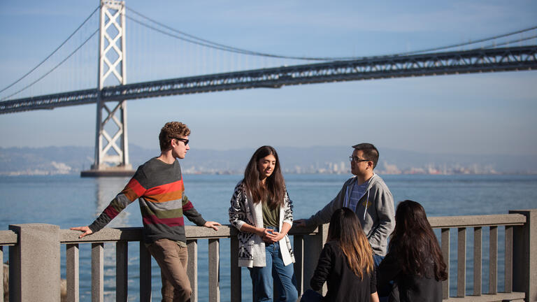 Five people in front of the Bay Bridge