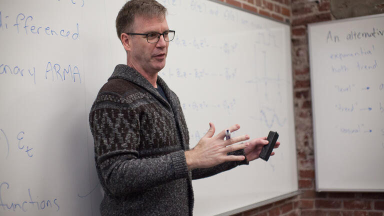 Professor teaching in front of a whiteboard