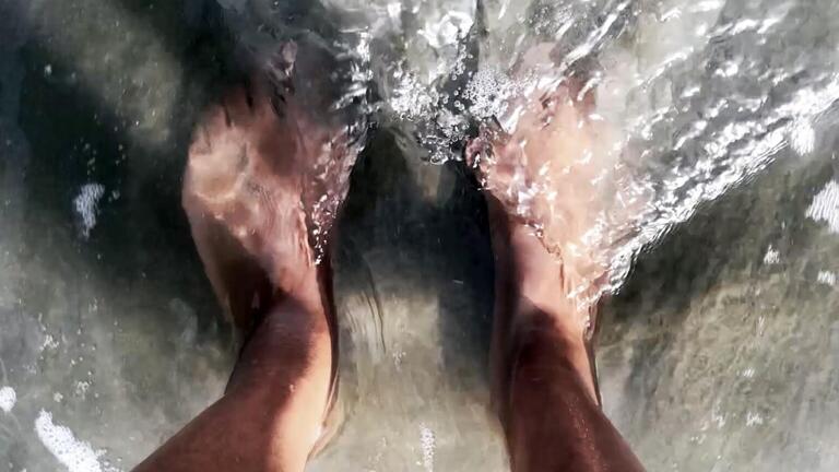 Close up of feet in water.