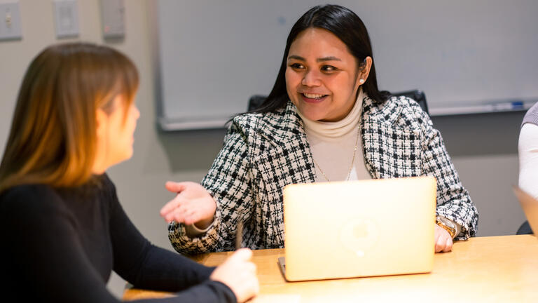 student speaking to another student in class