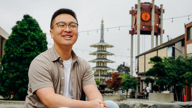 Student sits on a bench in SF's Chinatown.