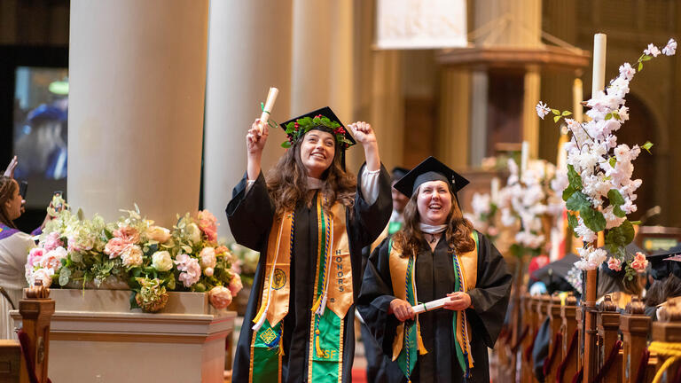 students walking down st ignatius church aisle during commencement