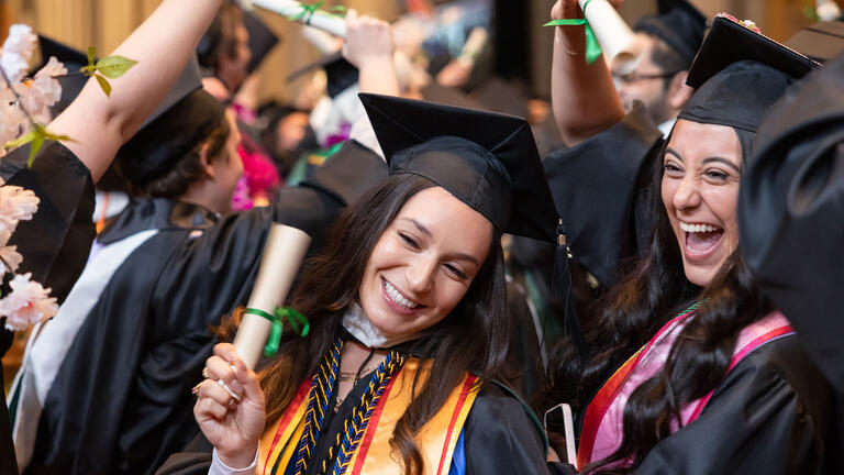 usf graduates smiling and holding diplomas