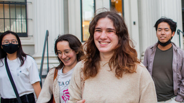 Four USF students smiling and walking together